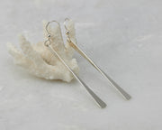 silver bar earrings on coral