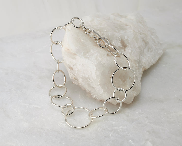 Silver chain link Bracelet closed on white rock