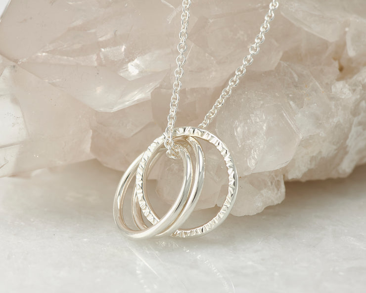 Silver interlocking unity necklace on crystal rock