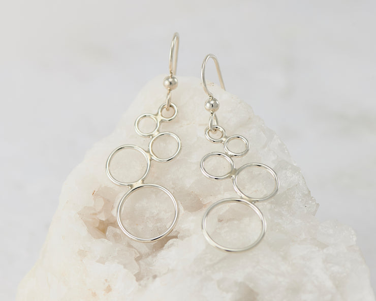 Silver circles chandelier earrings on white rock