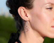 close up of woman wearing silver circles chandelier earrings