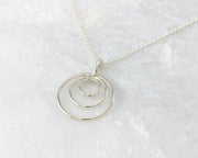 silver circles necklace on white marble