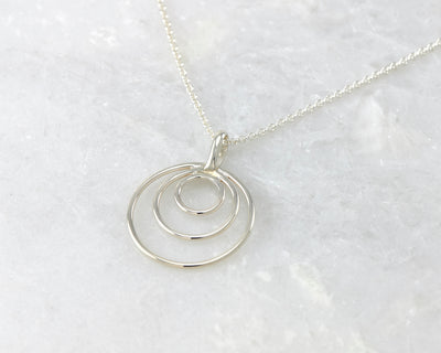 silver circles necklace on white marble