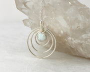 Silver opal circles necklace on crystal rock