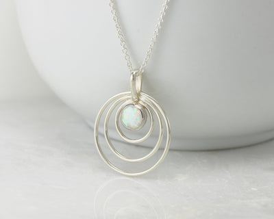 Silver opal circles necklace on white cup