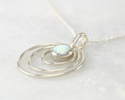 Silver opal circles necklace on white marble