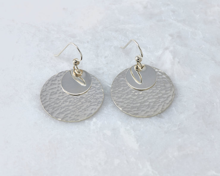Silver polished hammered discs earrings on white marble