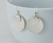 Silver hammered discs earrings on white cup