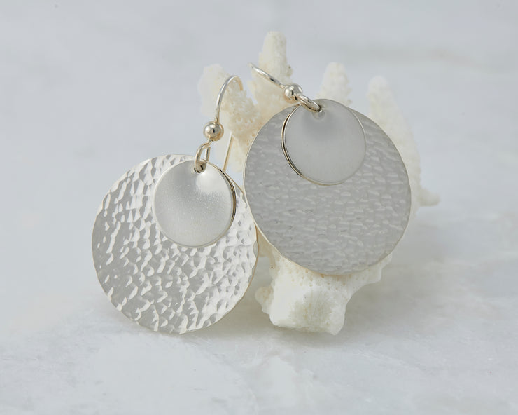 Silver hammered discs earrings on coral