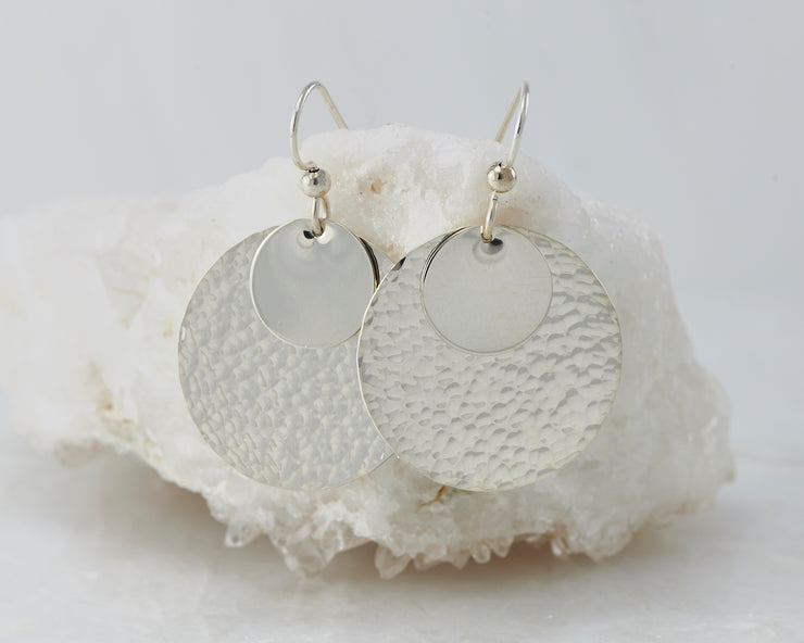 Silver hammered discs earrings on white rock
