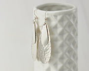 Silver teardrops earrings on geometric vase
