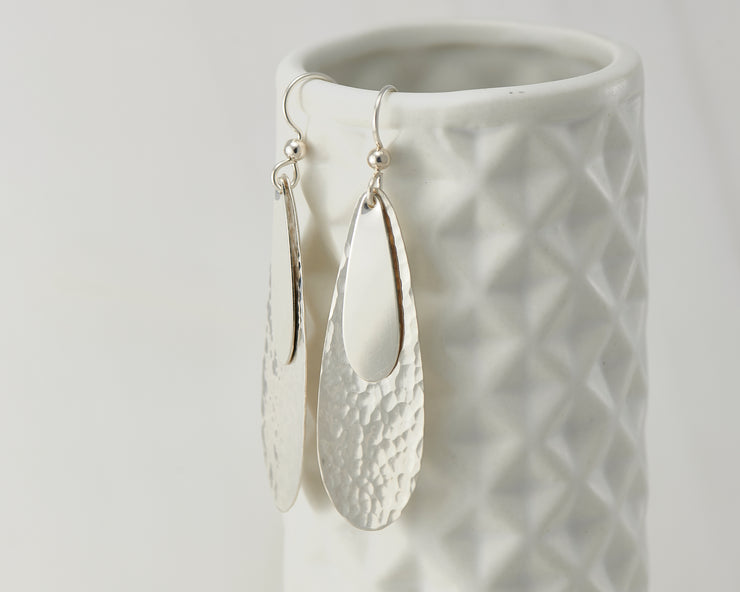 Silver teardrops earrings on geometric vase