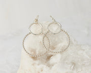 Silver beaded circles hoop hoop earrings on white rock