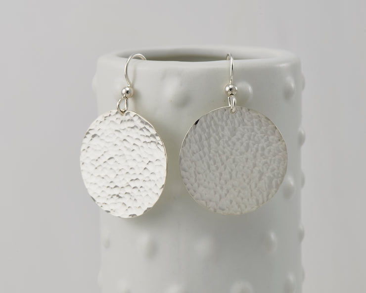 Circle Hammered earrings hanging on a dotted vase