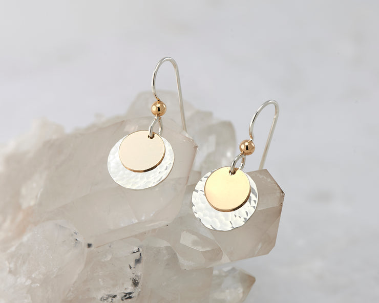 silver and gold disc earrings on quartz