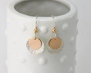 silver and gold disc earrings on dotted vase