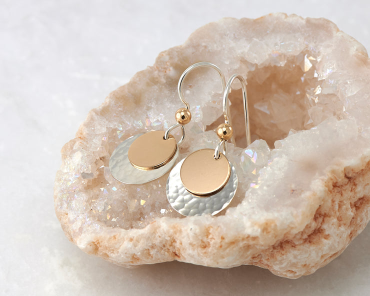 silver and gold disc earrings on quartz