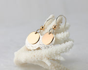 silver and gold disc earrings on coral