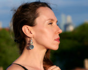 Silver disc earrings being worn by a woman