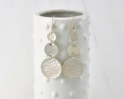 Circle Hammered earrings hanging on a dotted vase