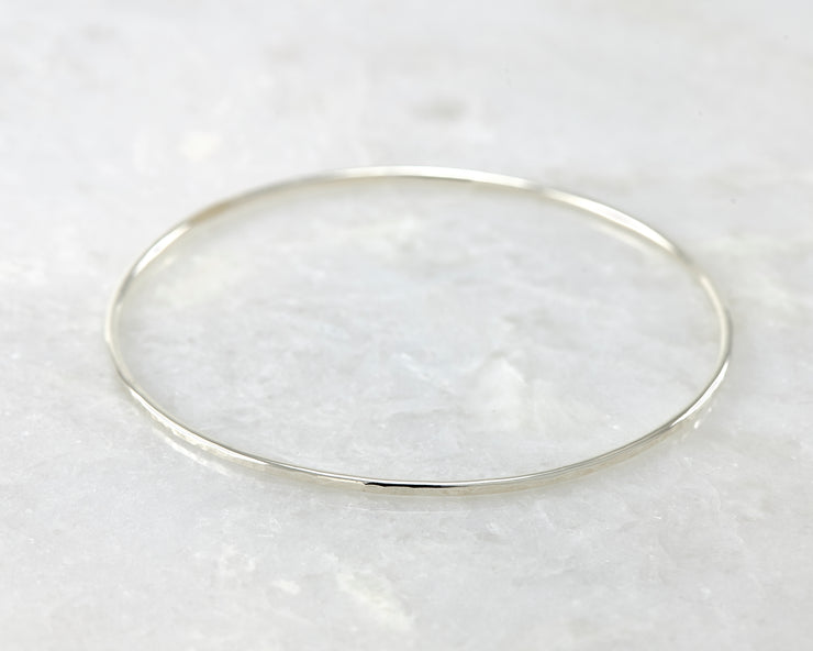 latch style hammered silver bangle bracelet open on marble