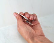 woman holding silver wave cuff bangle