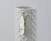 silver hammered teardrop earrings on geometric vase