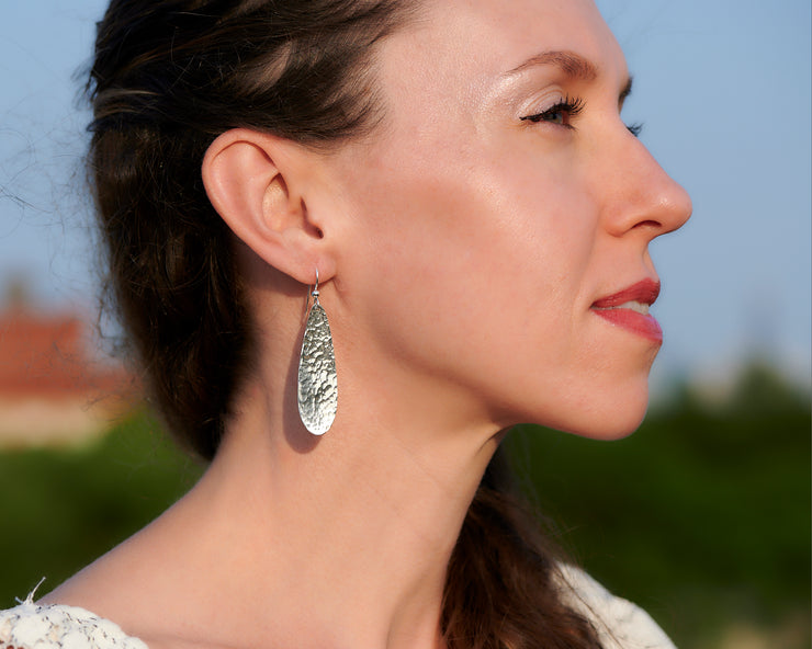 woman wearing silver hammered teardrop earrings