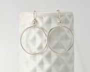 Silver medium hoop earrings on geometric vase