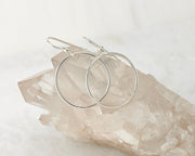Silver medium hoop earrings on crystal rock