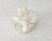 Silver medium hoop earrings on coral