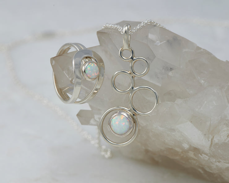 Silver opal ring and silver opal necklace on crystal