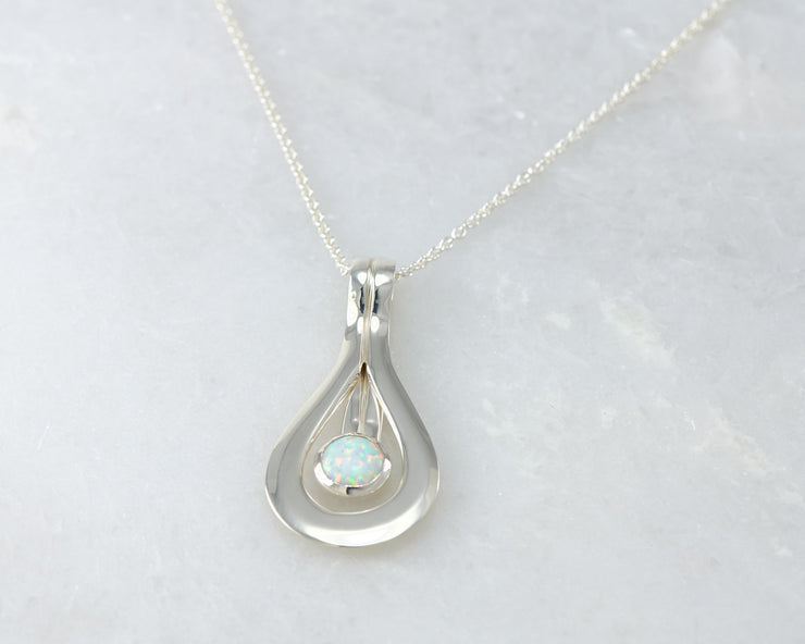 Silver opal pendant on white marble