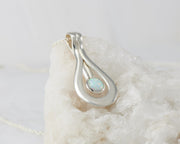 Silver opal pendant on white rock