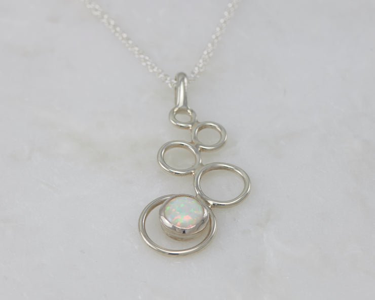 silver opal pendant on white marble