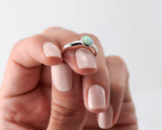 woman balancing silver opal ring