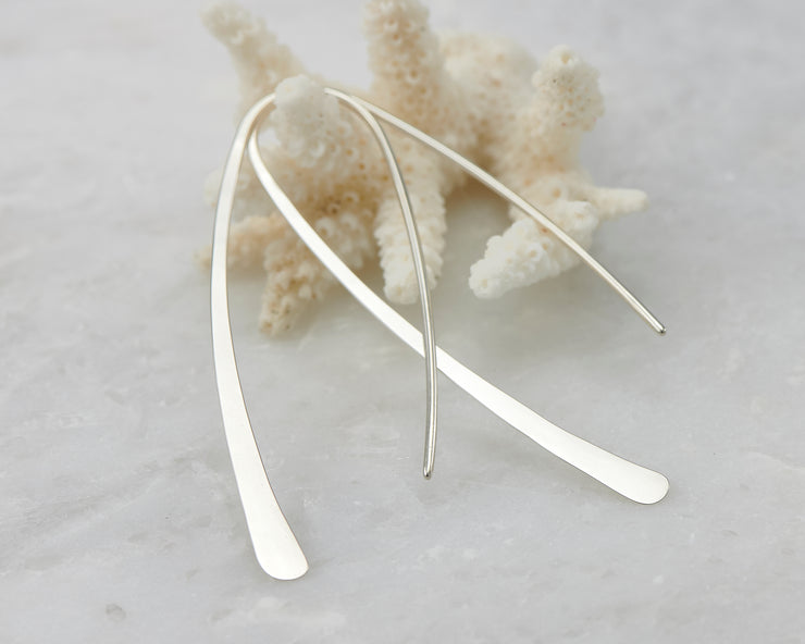 Sterling Silver hoop earrings hanging from coral