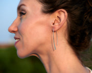 Silver open hoop earrings being worn by a woman
