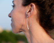 Open hoop dangle earrings being worn by a woman