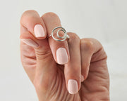 woman holding silver circles ring