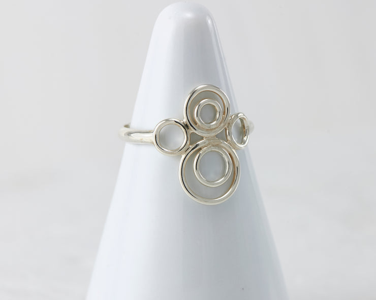 White ring holder with many circles Silver ring