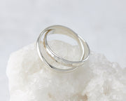 Silver interlocking russian wedding rings on white rock