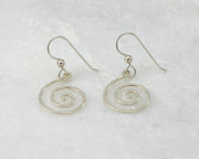 silver spiral earrings on white marble