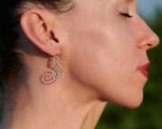 woman wearing silver spiral earrings facing out