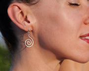 woman wearing silver spiral earrings