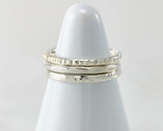 White rings holder with hammered Silver stacking rings