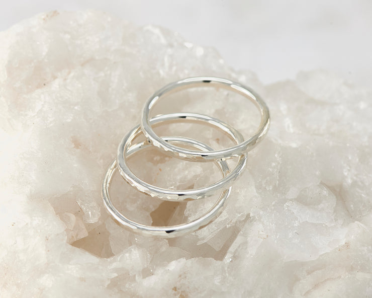 Silver hammered stacking rings on white rock