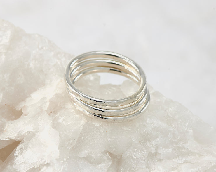 Silver hammered stacking rings on white rock