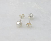 Silver hammered stud earrings on white marble