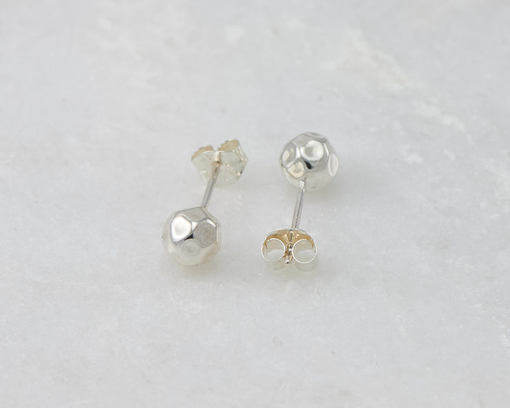 Silver hammered stud earrings on white marble